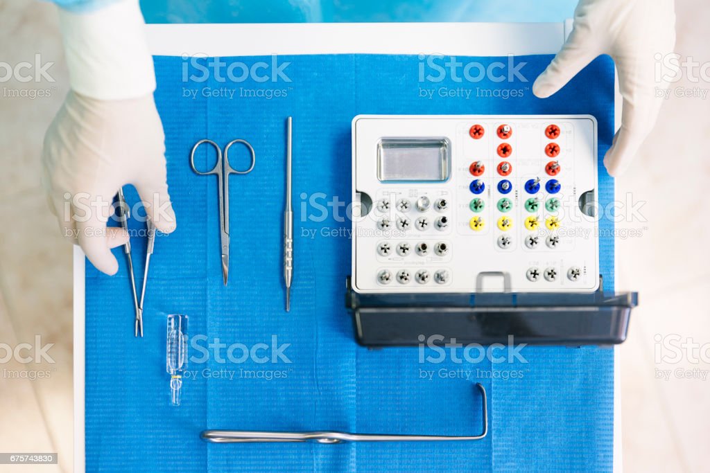 Detail of hand holding dental tools in dental clinic. Dentist Concept.